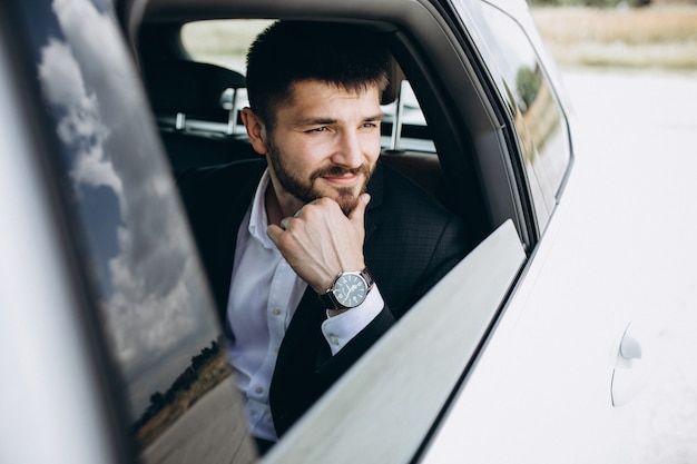 Bel homme d'affaires voyageant dans une voiture