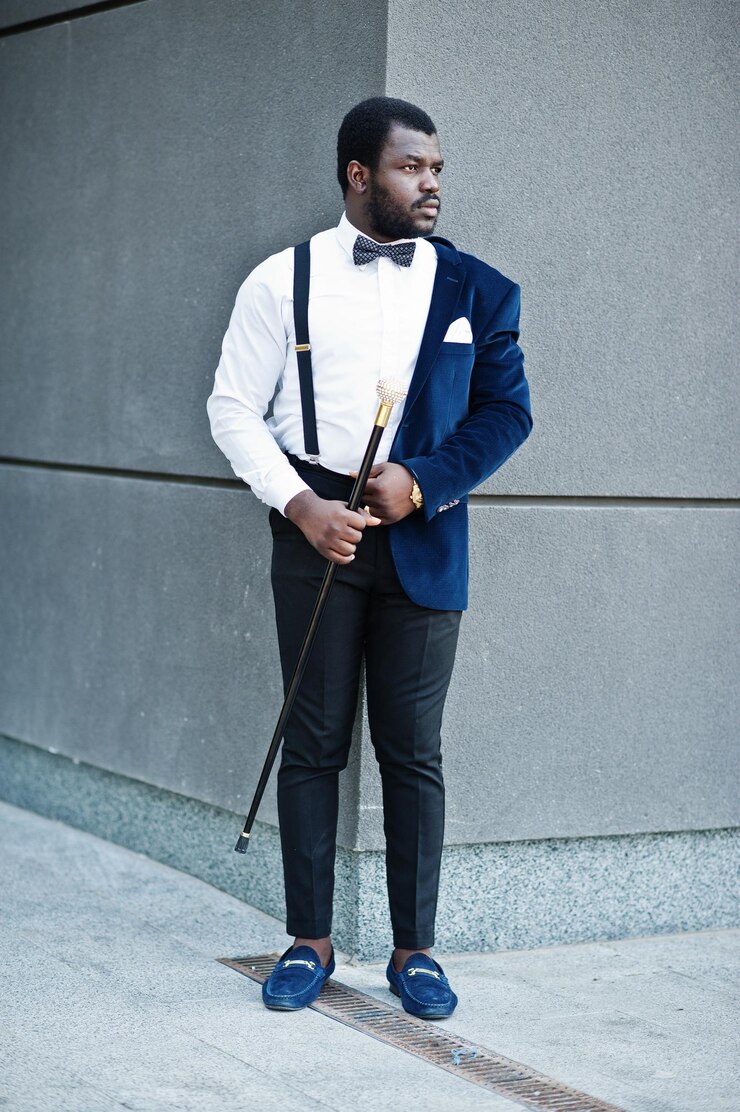 Photo gratuit un bel homme afro-américain à la mode en tenue formelle et un nœud papillon avec un bâton de marche.