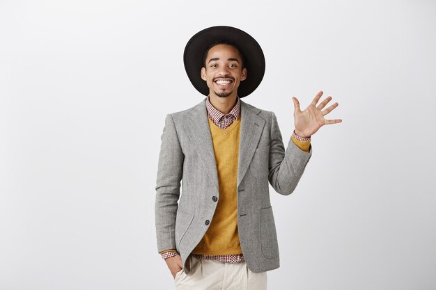 Bel homme afro-américain souriant en costume élégant montrant le numéro cinq, passer commande