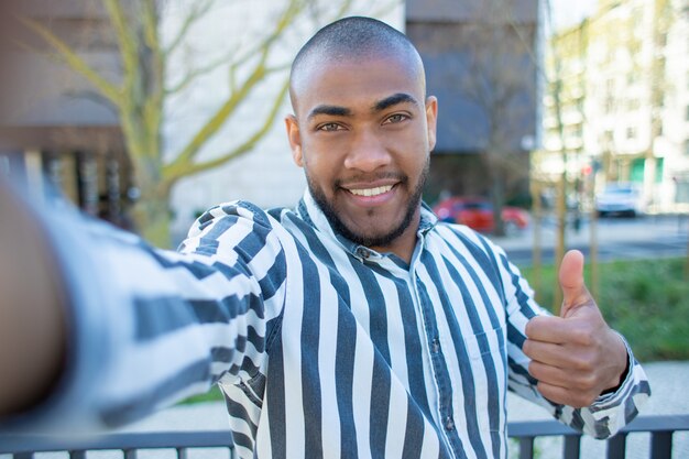 Bel homme afro-américain souriant montrant le pouce vers le haut