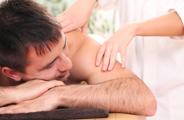 Bel homme appréciant la procédure de massage