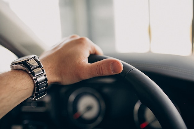 Bel homme assis dans la voiture et le tester