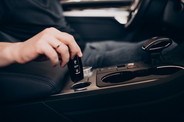 Bel homme assis dans la voiture et le tester