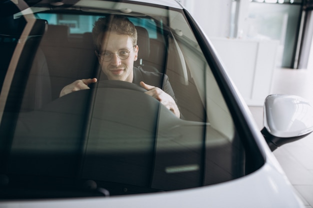 Photo gratuite bel homme assis dans une voiture