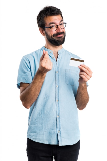 Bel homme aux lunettes bleues tenant une carte de crédit