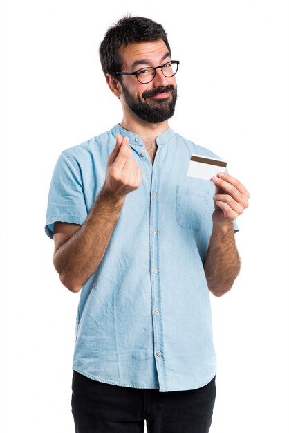 Bel homme aux lunettes bleues tenant une carte de crédit