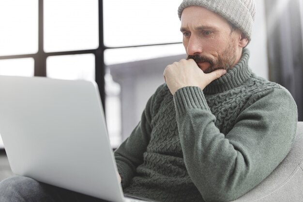 Bel homme avec barbe et ordinateur portable