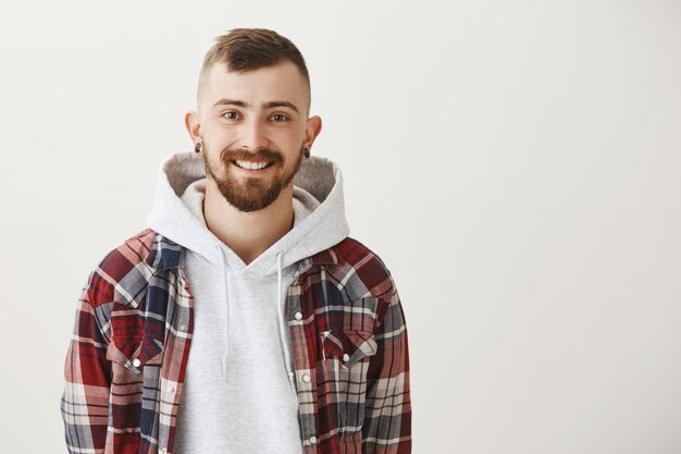 Bel homme barbu souriant heureux et regardant devant