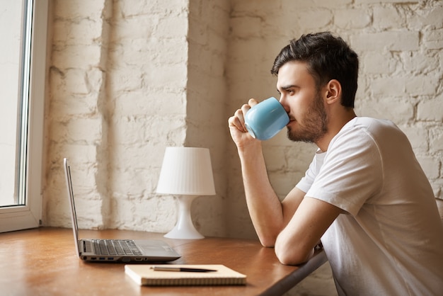 Bel homme buvant du café après un travail indépendant