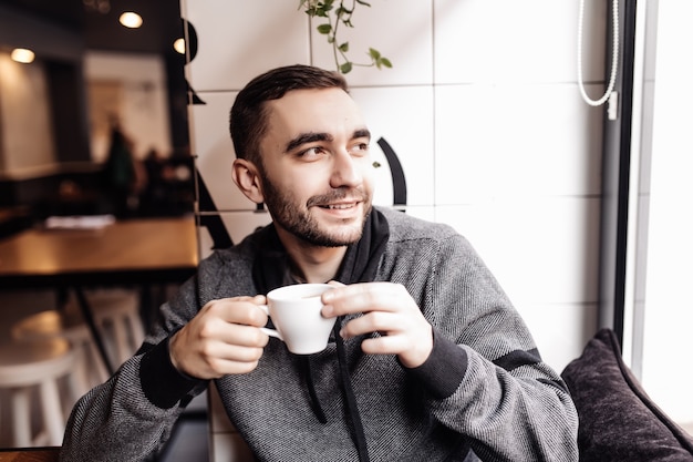 Bel homme buvant une tasse de café dans le café