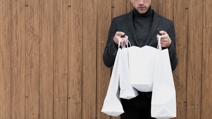 Photo gratuit bel homme cherche dans sacs à provisions