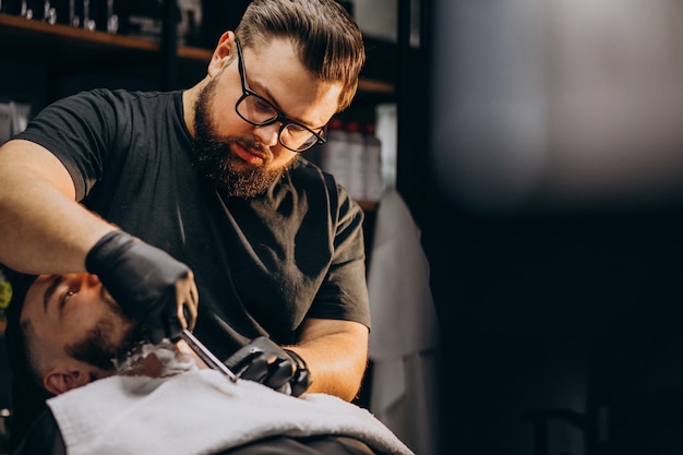 Bel homme coupe la barbe dans un salon de coiffure