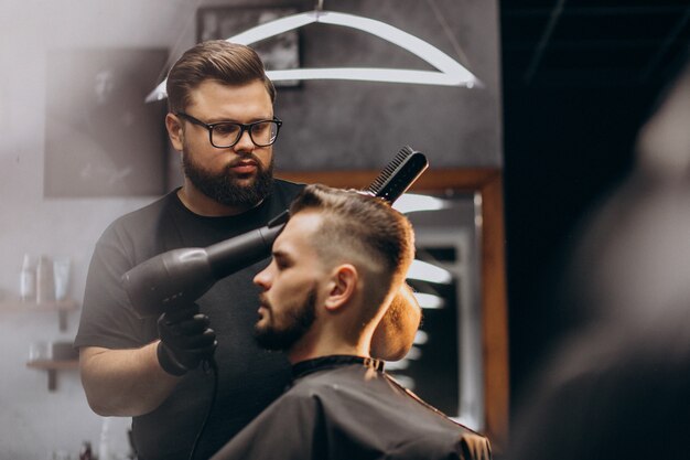 Bel homme dans un salon de coiffure coiffant les cheveux