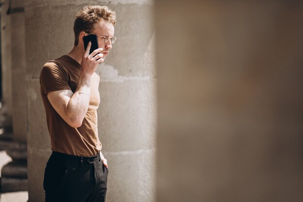 Bel homme dans des spectacles à l&#39;aide de téléphone