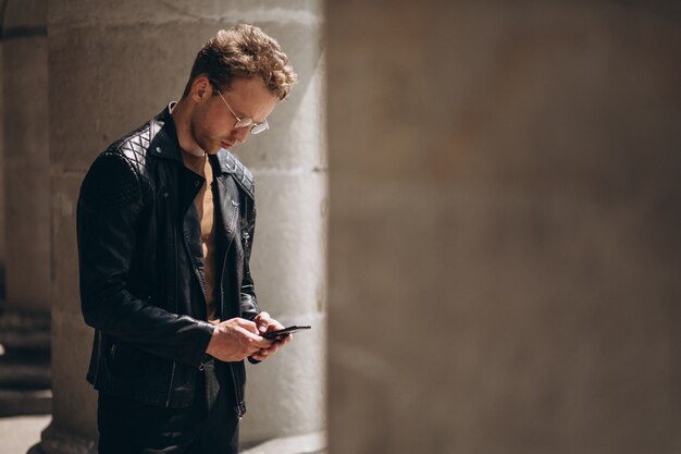 Bel homme dans des spectacles à l&#39;aide de téléphone