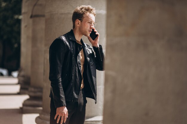 Bel homme dans des spectacles à l&#39;aide de téléphone