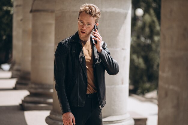 Bel homme dans des spectacles à l&#39;aide de téléphone