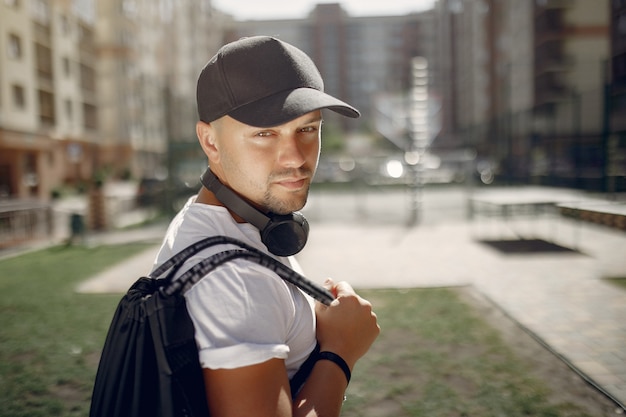 Bel homme debout dans un parc avec des écouteurs