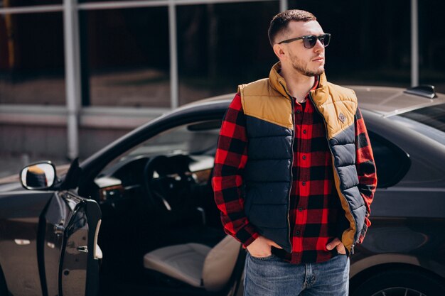 Bel homme debout près de la voiture