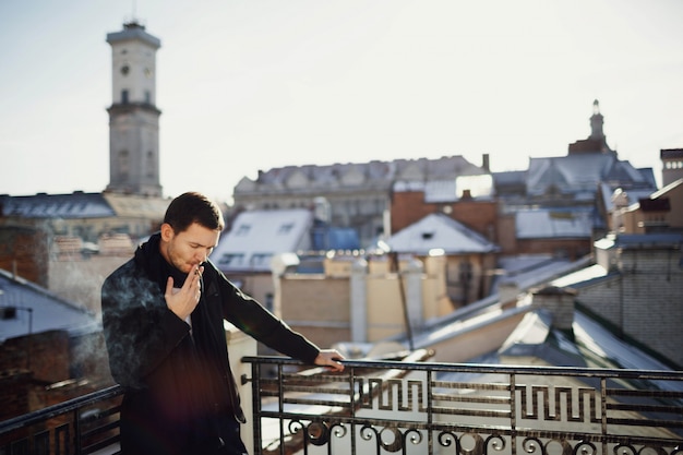 Photo gratuite bel homme debout sur la terrasse avec de belles vues