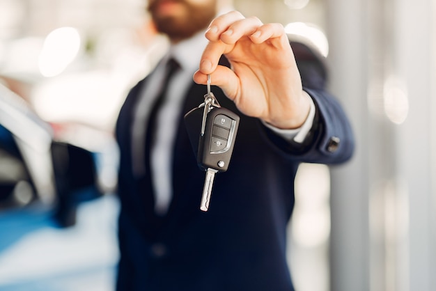 Bel homme élégant dans un salon de l&#39;automobile