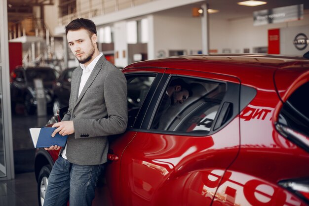 Bel homme élégant dans un salon de l&#39;automobile