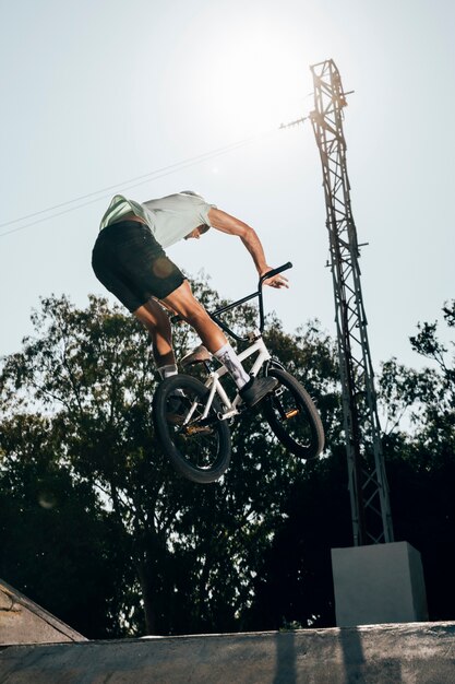 Bel homme faisant des tours sur skate park