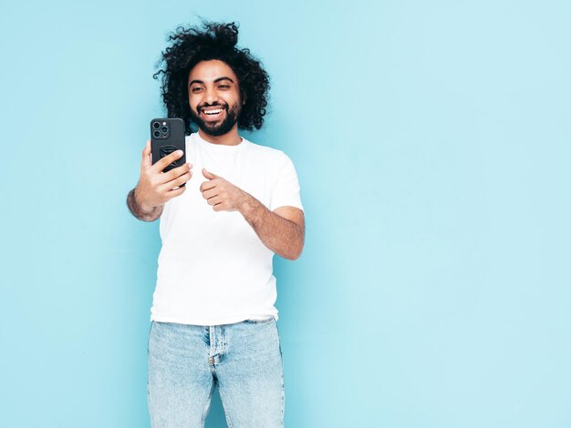 Bel homme hipster souriant qui pose en studio