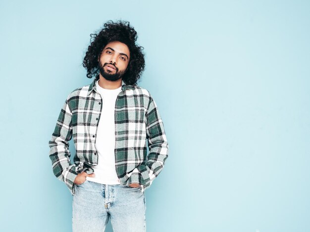 Bel homme hipster souriant qui pose en studio