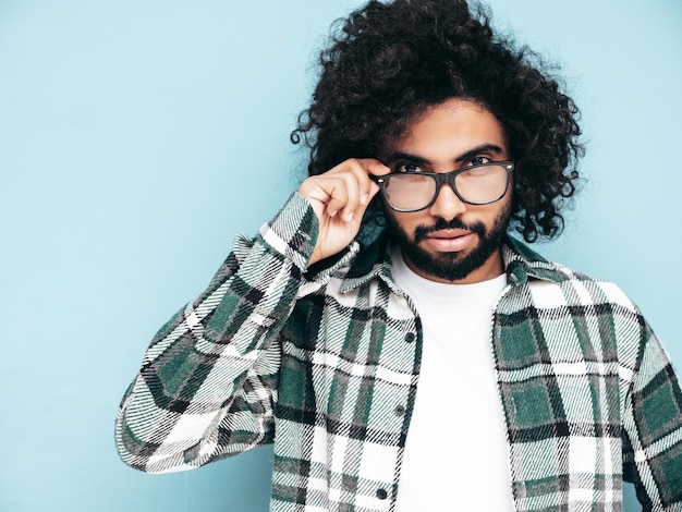 Bel homme hipster souriant qui pose en studio