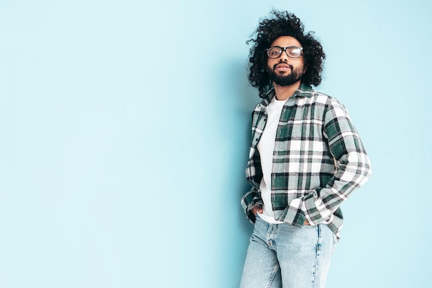 Bel homme hipster souriant qui pose en studio