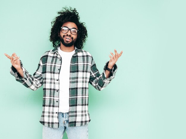 Bel homme hipster souriant qui pose en studio