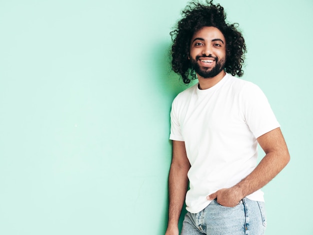 Bel homme hipster souriant qui pose en studio