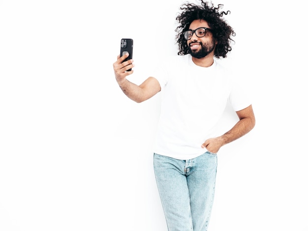 Photo gratuite bel homme hipster souriant qui pose en studio