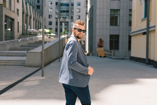 Bel homme à lunettes de soleil marchant dans la rue