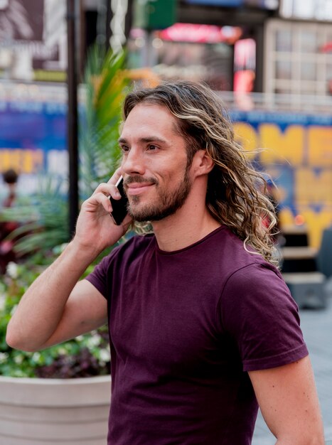 Bel homme marche et parle au téléphone