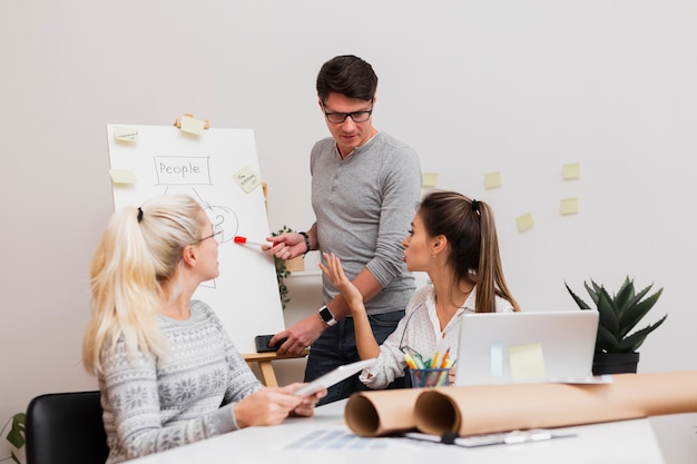 Bel homme montrant un diagramme à ses partenaires