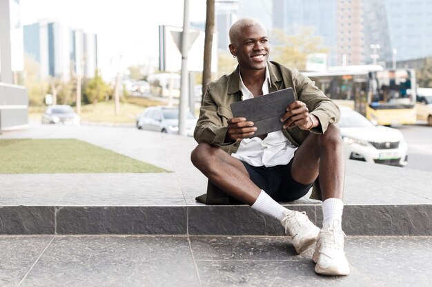 bel homme noir en plein air avec tablette