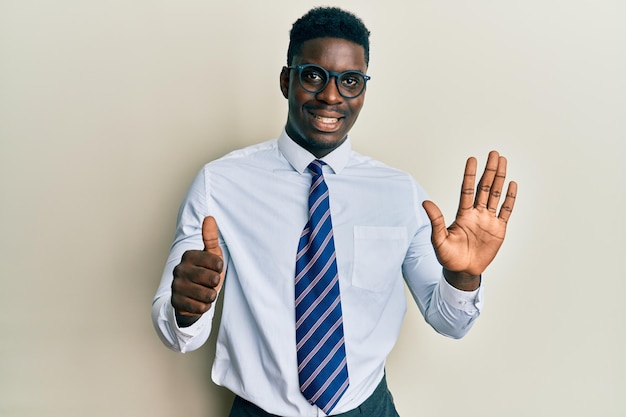 Photo gratuite bel homme noir portant des lunettes chemise et cravate d'affaires montrant et pointant vers le haut avec les doigts numéro six tout en souriant confiant et heureux.