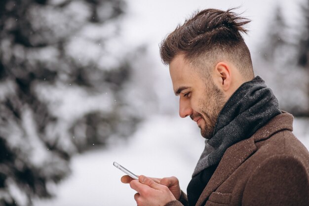 Bel homme parlant au téléphone dans un parc d&#39;hiver