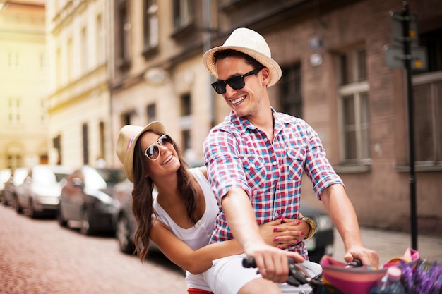 Photo gratuite bel homme prenant sa petite amie sur un porte-vélos