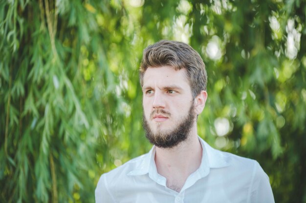 Bel homme de race blanche barbu dans un polo blanc