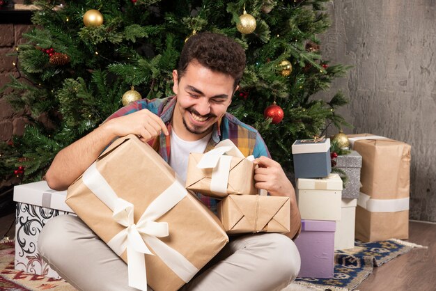 Bel homme souriant avec ses cadeaux.