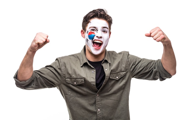 Photo gratuite bel homme supporter fan de l'équipe nationale de la république de corée avec le visage du drapeau peint obtenir une victoire heureuse en criant dans une caméra. émotions des fans.