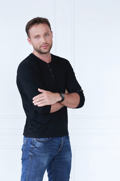 Bel Homme Avec T-shirt Noir Et Jeans Posant