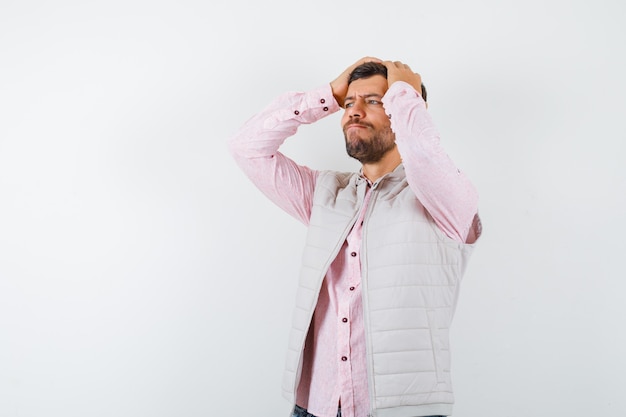 Photo gratuite bel homme tenant les mains sur la tête en gilet, chemise et à la recherche de remords.