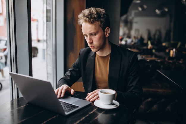 Bel Homme Travaillant Sur Un Ordinateur Dans Un Café Et Boire Un Café