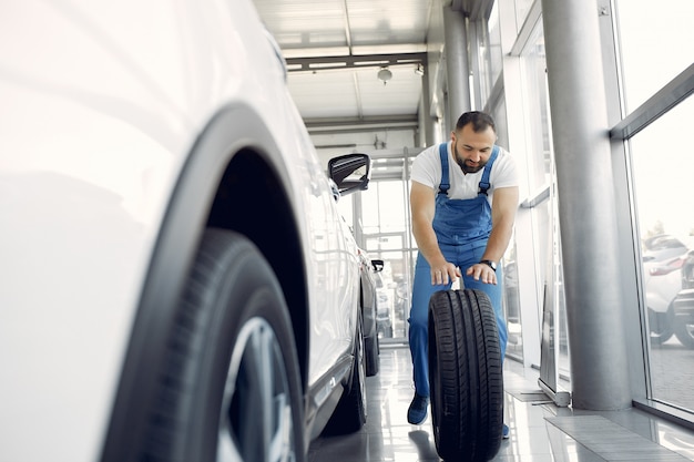 Bel homme en uniforme bleu vérifie la voiture