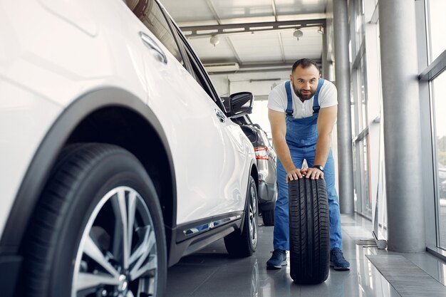 Bel homme en uniforme bleu vérifie la voiture