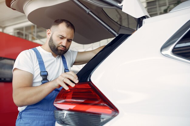 Bel homme en uniforme bleu vérifie la voiture